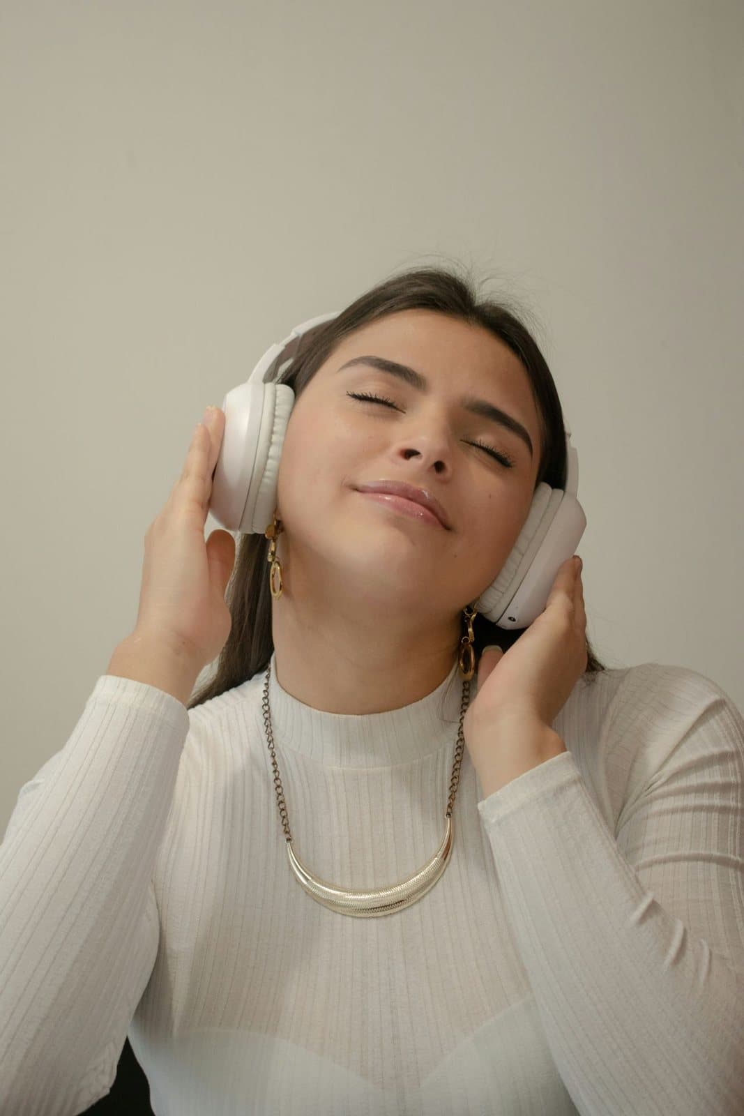 Woman wearing headphones with her eyes closed, absorbed in music, reflecting ADHD therapy that works with how you focus